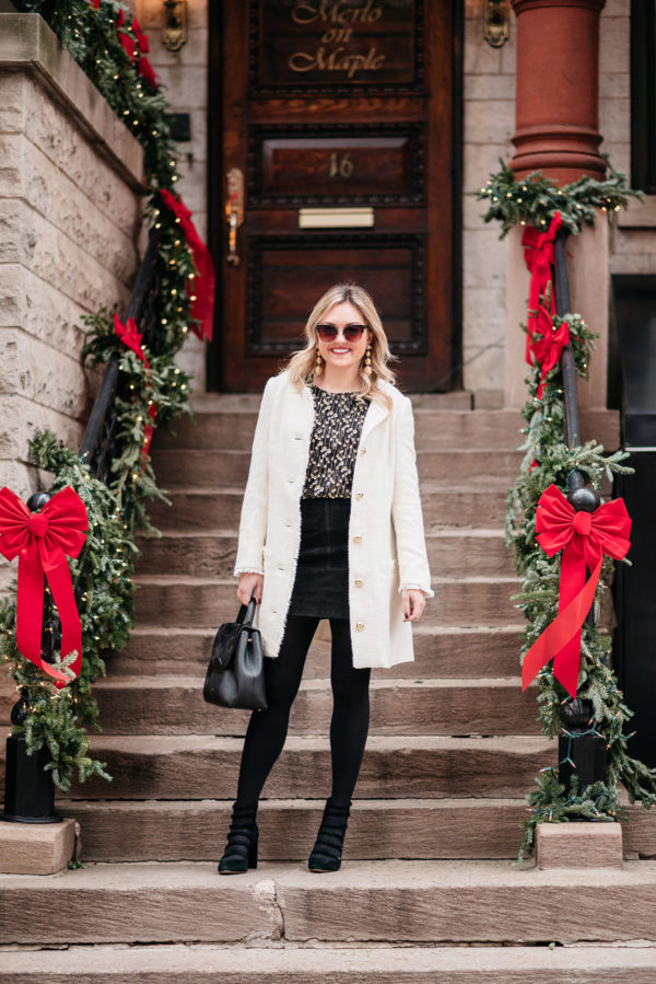 Jessica Sturdy styling a white winter coat with a black and gold outfit for the holidays.