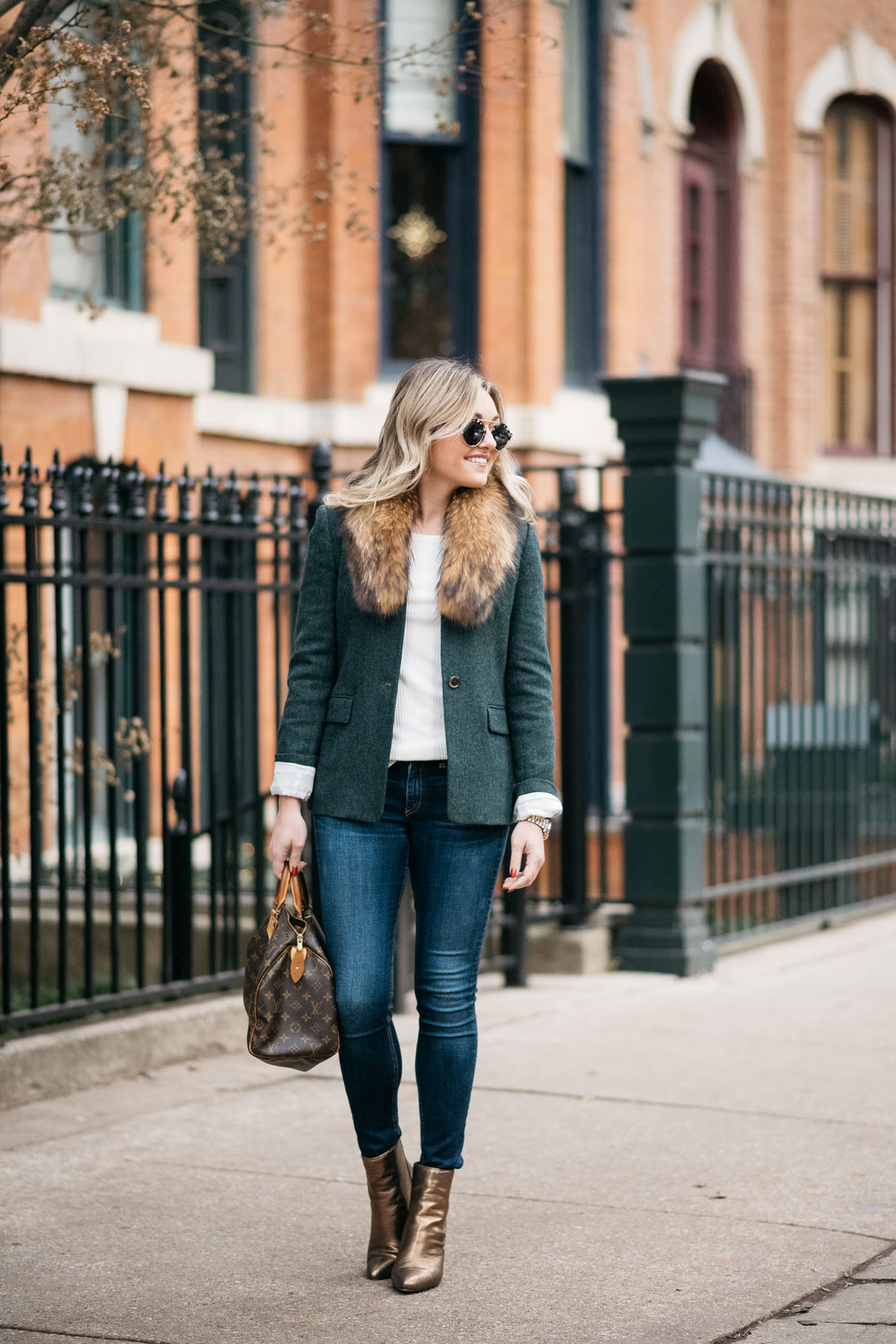 Chicago lifestyle blogger Jessica Sturdy wearing a green J.Crew blazer, an Old Navy ribbed tee, a fur collar from Paris, Rag & Bone skinny jeans, and Vince Camuto bronze booties with a Louis Vuitton monogrammed handbag, Illesteva Milan tortoise sunglasses, and a Michael Kors watch.