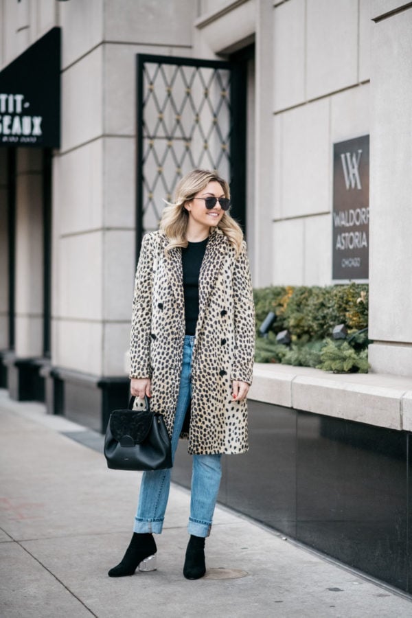 Chicago blogger Jessica Sturdy wearing Le Specs matte black Prince aviators, Bows & Sequins leopard coat, Old Navy black ribbed sweater, Levi's 501 boyfriend jeans, and Steve Madden lucite booties with a Polene Paris black top-handle bag.
