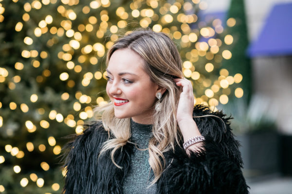 Jessica Sturdy wearing sparkly earrings, a silver dress, and a black fur coat.