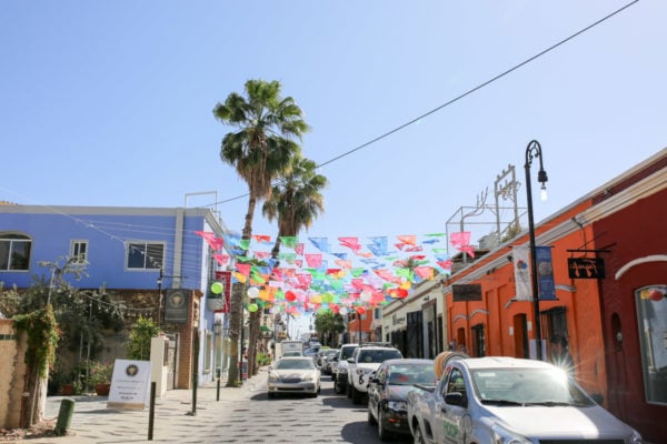 Jessica Sturdy shares photos from exploring San Jose del Cabo in Mexico. Colorful flags hanging between buildings.
