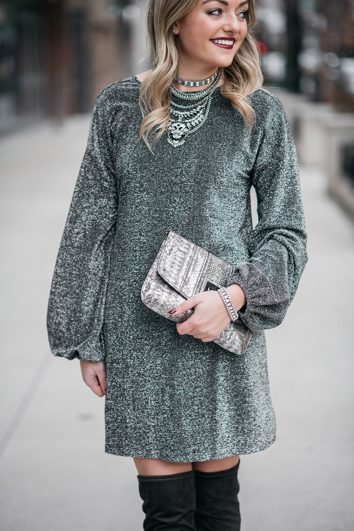 Jessica Sturdy styling a long sleeve silver glittery dress with grey over the knee boots.