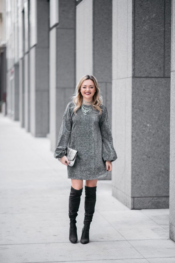 Bows & Sequins wearing a long sleeve silver dress with over the knee boots.