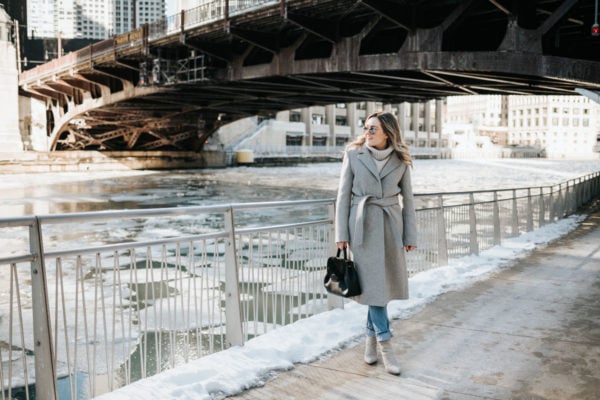 Chicago lifestyle blogger Jessica Rose Sturdy wearing a Claudie Pierlot grey wool coat, grey cashmere sweater, boyfriend jeans, and grey suede booties with mirrored sunglasses and a Polene top handle bag.