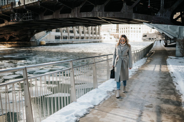 Chicago blogger Jessica Rose Sturdy wearing a Claudie Pierlot grey wool coat, Vineyard Vines grey cashmere sweater, Rag & Bone boyfriend jeans, and Linea Paolo grey suede booties with mirrored sunglasses and a Polene Paris satchel.