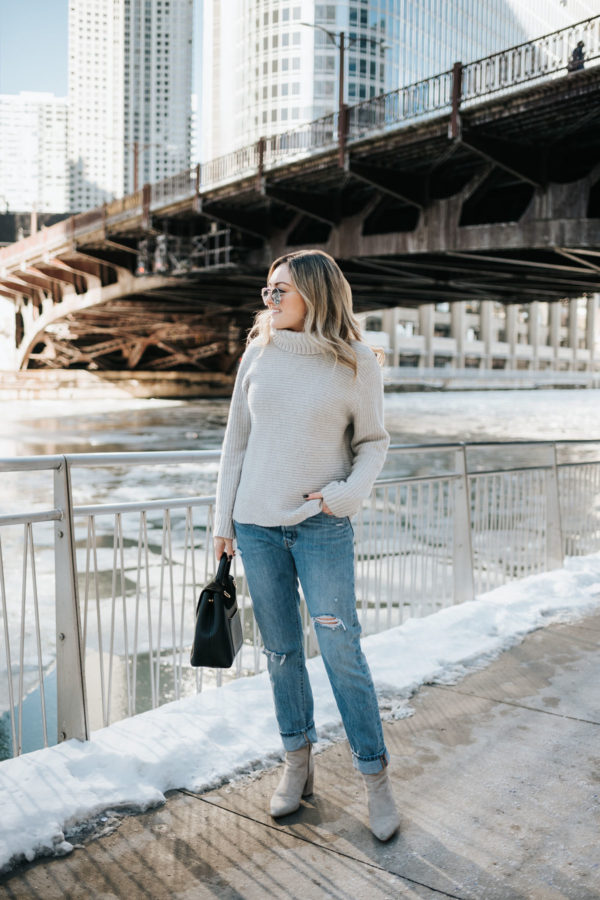 Jessica Sturdy wearing a grey Vineyard Vines cashmere sweater, Rag & Bone boyfriend jeans, mirrored sunglasses, and grey suede booties with a Polene Paris bag.