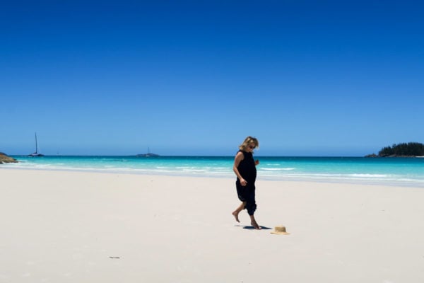 Jessica Sturdy on Whitehaven Beach in the Whitsundays in Australia wearing a navy blue maxi dress.