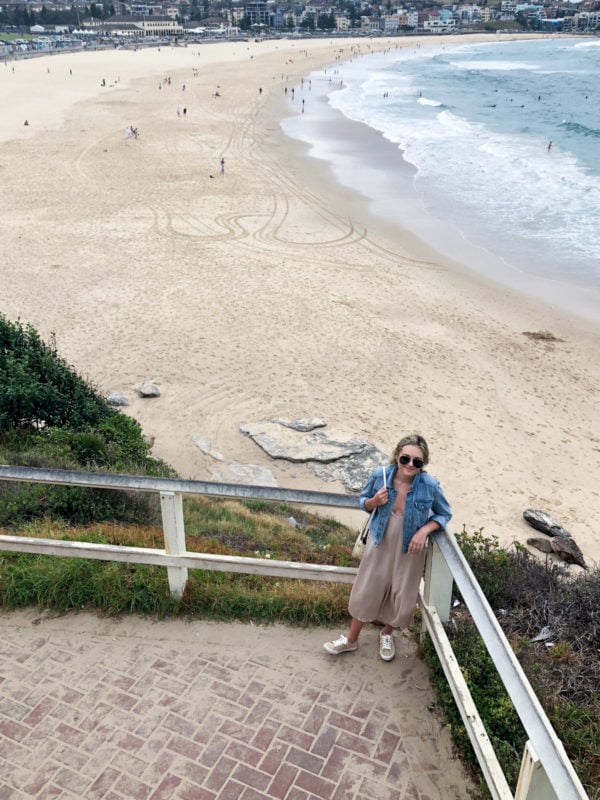 Jessica Sturdy wearing a jean jacket and jumpsuit with sneakers in Bondi Beach Australia