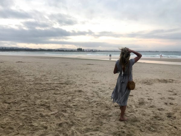 Jessica Sturdy wearing a blue and white striped dress on the beach in Byron Bay Australia