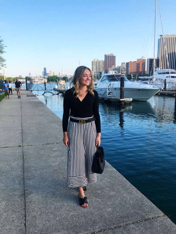 Jessica Sturdy wearing a black bodysuit, Gucci belt, black & white striped pants, and Kate Spade bow sandals by Belmont Harbor in Chicago.