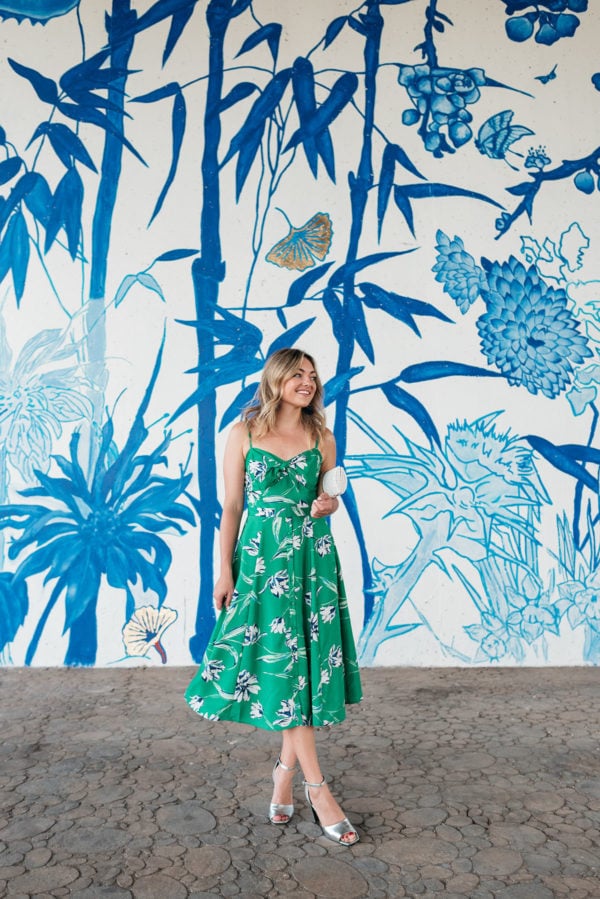 Chicago personal stylist Jessica Sturdy wearing a green floral midi dress in front of a blue and white chinoiserie mural in Chinatown in Chicago.