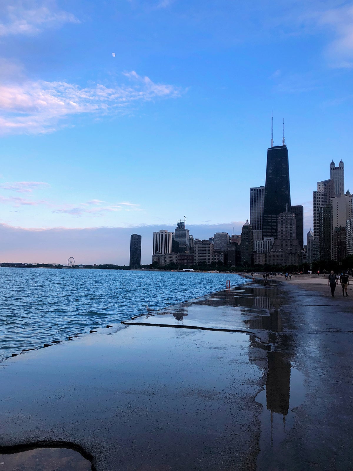 Pink and blue skies at sunset over Lake Michigan with the Chicago skyline and Hancock Building on the Lakefront Path