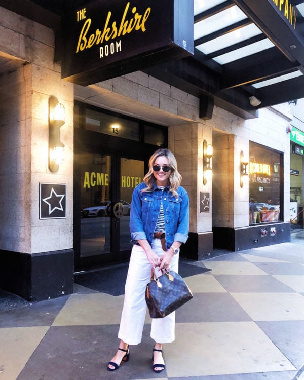 Chicago lifestyle blogger wearing a denim jacket, striped shirt, wide leg white jeans, and a Louis Vuitton Speedy bag.