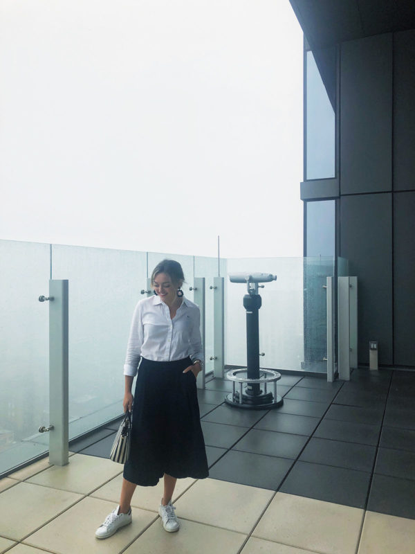 Chicago blogger wearing a Vineyard Vines white button down shirt, wide leg navy pants, and white Adidas Stan Smith sneakers.