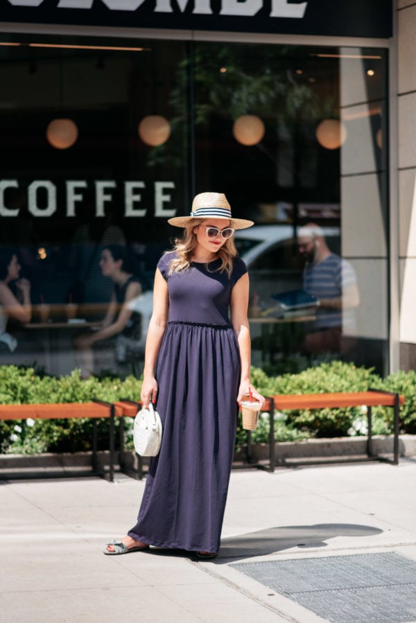 Chicago beauty blogger Jessica Sturdy wearing a blue maxi dress and striped straw hat in front of La Colombe Coffee in the Gold Coast.