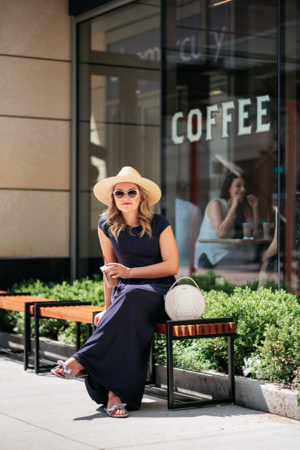 Personal Stylist Jessica Sturdy styling a straw hat and navy blue maxi dress with a round handbag and bow slides for a quick coffee run in Chicago's Gold Coast at La Colombe.