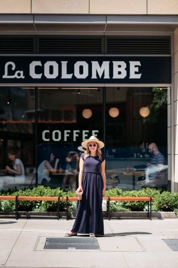 Chicago lifestyle blogger Jessica Sturdy at La Colombe Coffee in Chicago's Gold Coast neighborhood wearing a blue maxi dress, straw hat, and circle handbag.