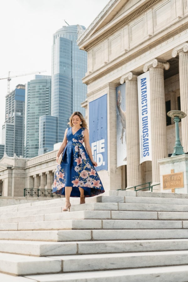 Chicago fashion blogger Jessica Sturdy wearing a blue floral dress in front of the Field Museum in Chicago for a wedding.
