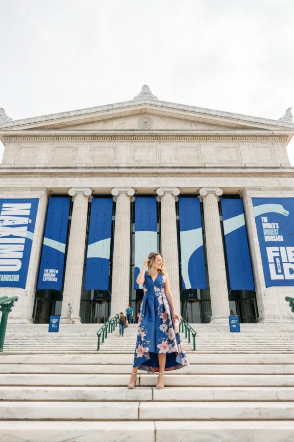 Chicago fashion blogger Bows & Sequins wearing a blue floral dress in front of the Field Museum for a fancy wedding.