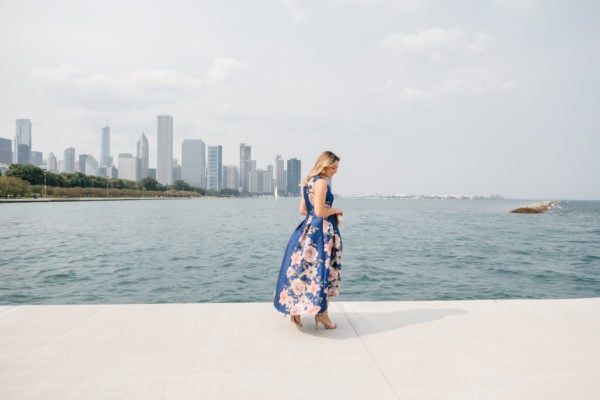 Chicago-based fashion Instagrammer Jessica Sturdy in front of Lake Michigan and the Chicago skyline wearing a formal blue and pink floral dress.