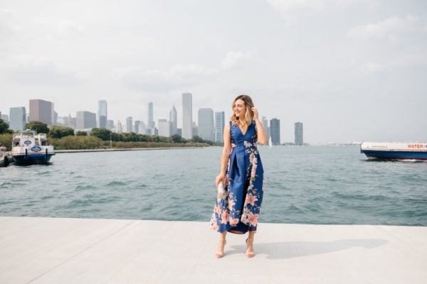 Fashion blogger Jessica Sturdy wearing a blue floral dress in front of the Chicago skyline along Lake Michigan by Museum Campus.