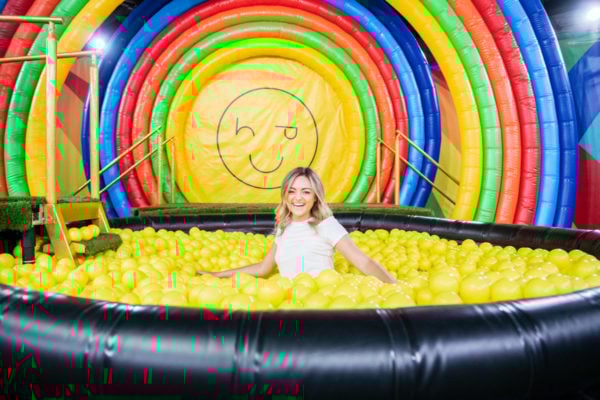 Chicago blogger Bows & Sequins in a rainbow ball pit at Happy Place