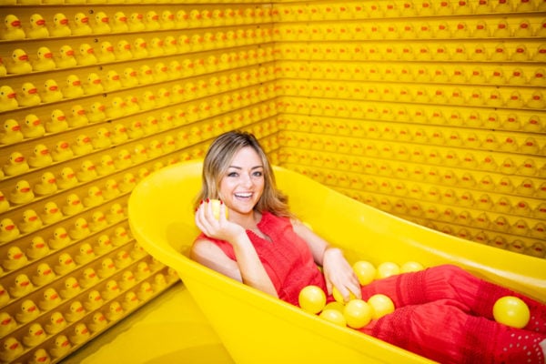 Jessica Sturdy, Chicago-based lifestyle blogger, at Happy Place in the yellow bathtub with rubber ducks.