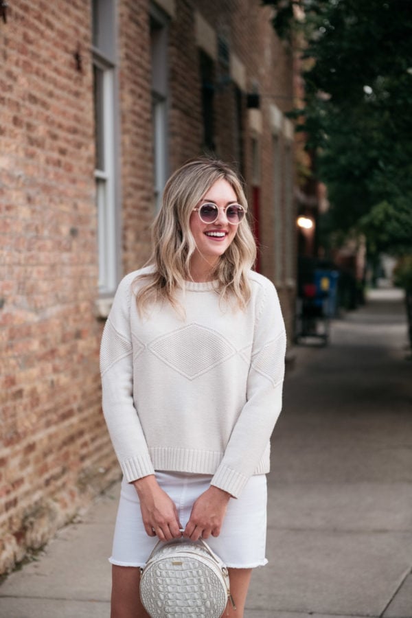 Chicago blogger Bows & Sequins wearing a Goat Fashion cashmere sweater and a white circle handbag.