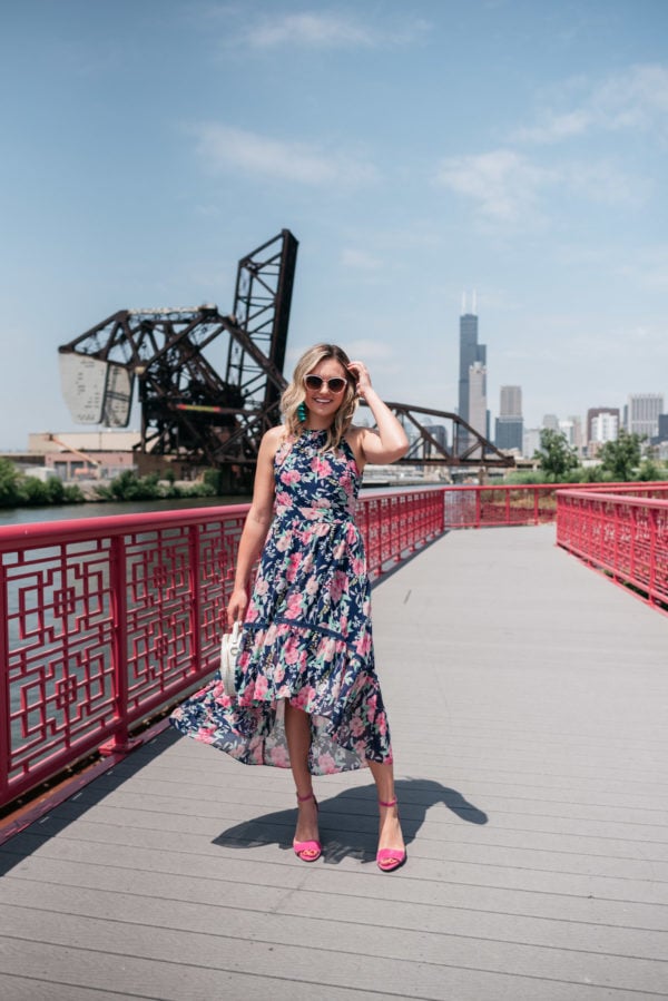Chicago style blogger Bows & Sequins wearing a pink and navy floral dress in front of the skyline.