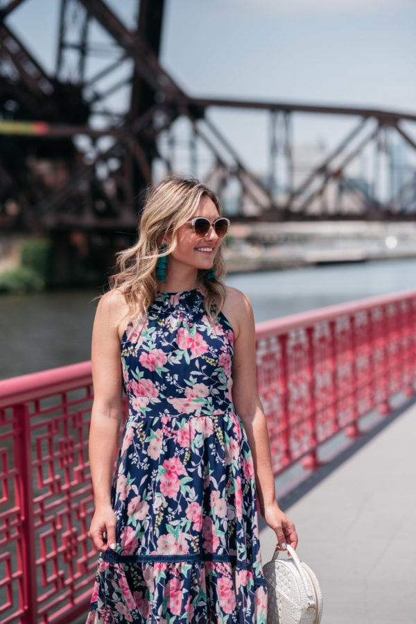 Chicago blogger Jessica Sturdy wearing a pink and navy floral dress by Eliza J with Bauble Bar earrings.