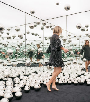 Chicago lifestyle blogger Jessica Sturdy of Bows & Sequins wearing a polka dot dress at the Infinity Mirrors room exhibit with the glass orbs.