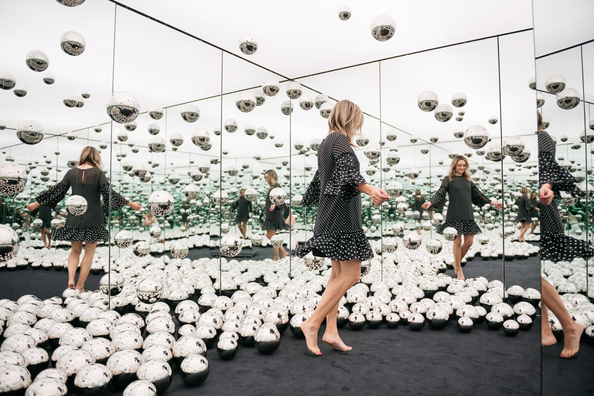 Chicago lifestyle blogger Jessica Sturdy of Bows & Sequins wearing a polka dot dress at the Infinity Mirrors room exhibit with the glass orbs.