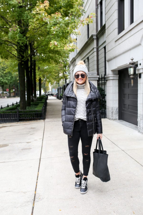 Health and fitness blogger Jessica Sturdy of Bows & Sequins wearing a black Barbour puffy coat with black jeans and sneakers.