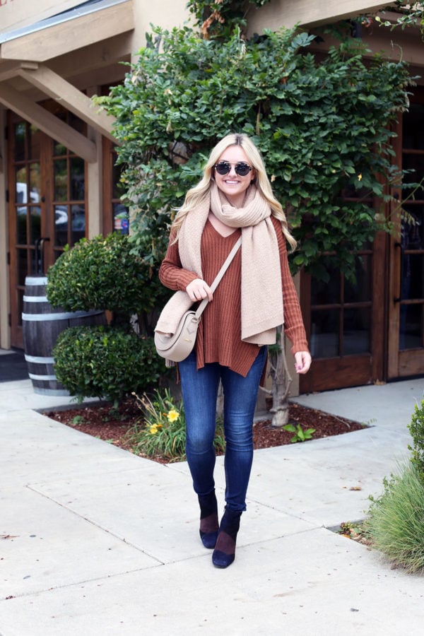 Fashion and travel blogger Jessica Sturdy of Bows & Sequins wearing an oversized cashmere scarf, skinny jeans, and booties for wine tasting in Napa.