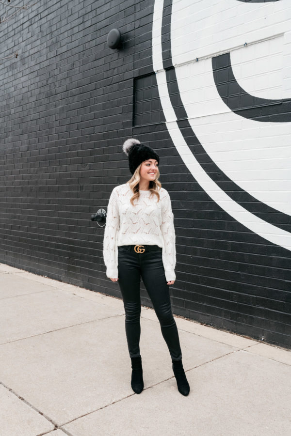 Chicago lifestyle influencer Jessica Sturdy wearing a fur beanie with a pom pom and a gucci belt.
