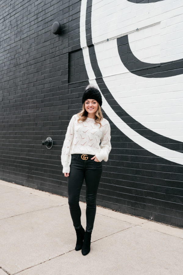 Chicago personal stylist Jessica Sturdy wearing a Kyi Kyi pom-pom beanie, a Nordstrom sweater, a Gucci belt, coated jeans from Express, and ankle boots for a cute winter outfit.