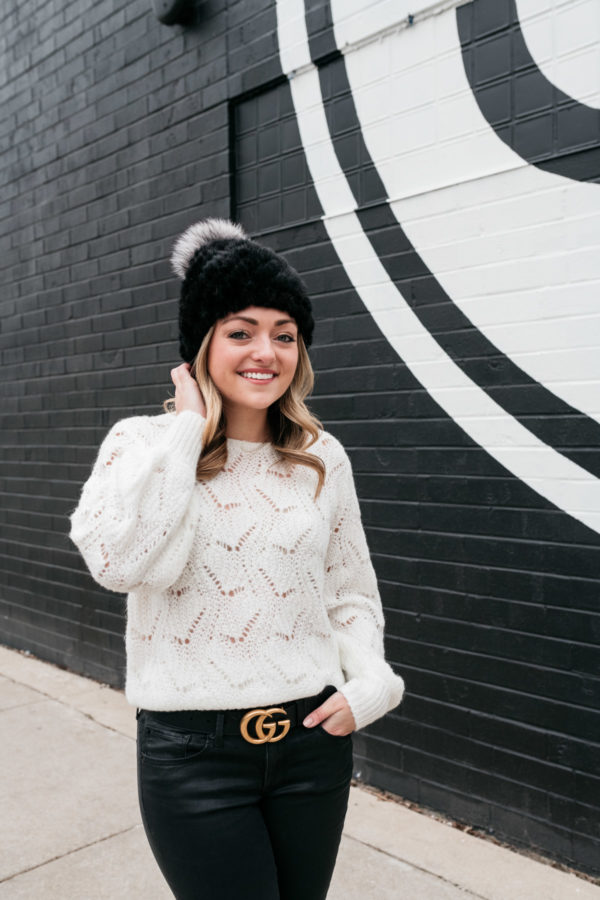Chicago influencer Jessica Sturdy styling a black beanie with a open stitchwork sweater and a Gucci belt.