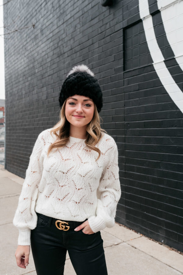 Chicago-based fashion blogger Jessica Sturdy wearing a black fur beanie by Kyi Kyi, a balloon sleeve sweater from Nordstrom, and a black and gold Gucci belt.