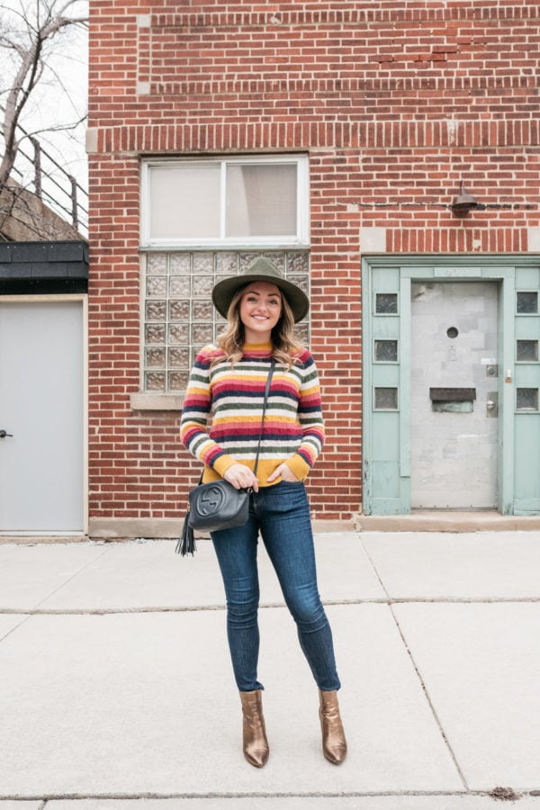 Chicago personal stylist Jessica Sturdy wearing an olive green Barbour hat with a striped sweater, Gucci bag, Rag & Bone skinnies, and metallic bronze ankle booties.