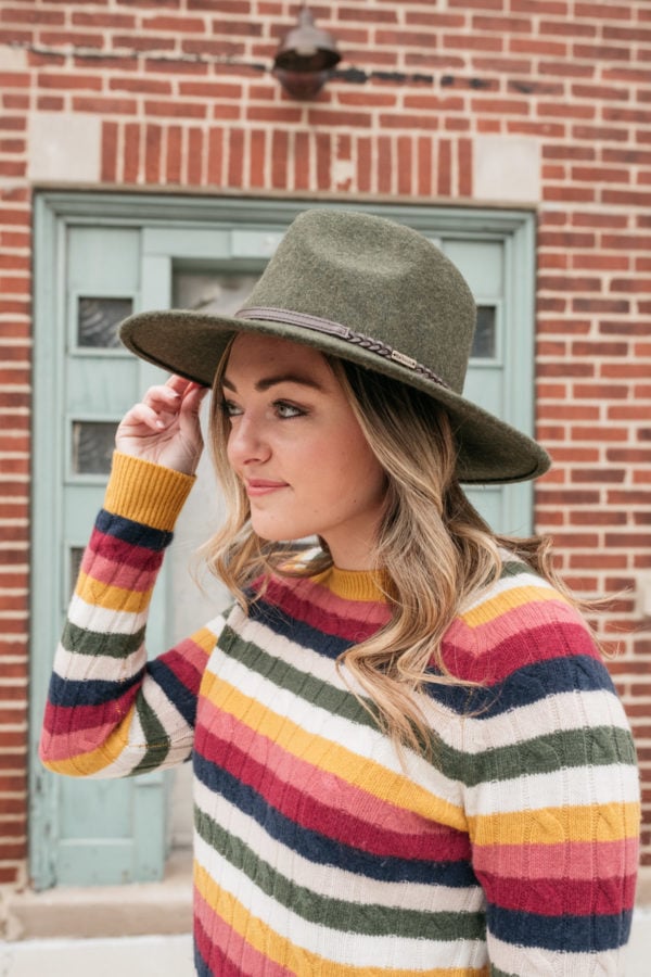 Chicago influencer Bows & Sequins wearing a Barbour tack fedora in olive with a cable knit cashmere crewneck sweater from Nordstrom.