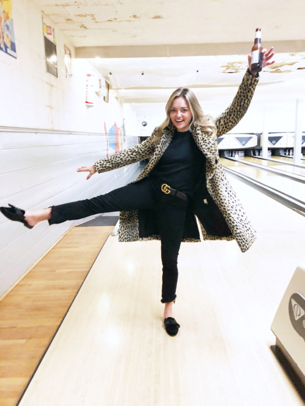 Chicago blogger wearing an all black outfit with a leopard coat, bow slide mules, and a Gucci belt.