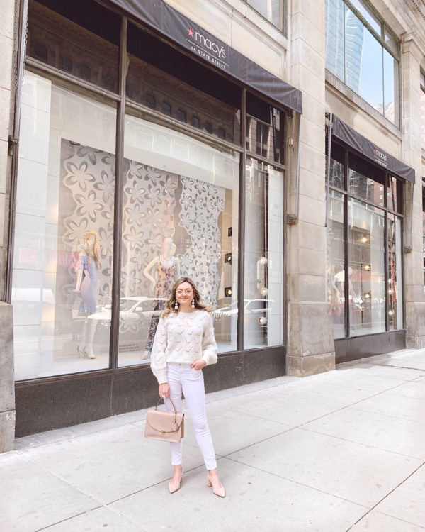 Chicago personal stylist Jessica Sturdy wearing a cream pointelle sweater with white jeans, a blush leather structured tote, nude suede slingbacks, and goldrim glasses.