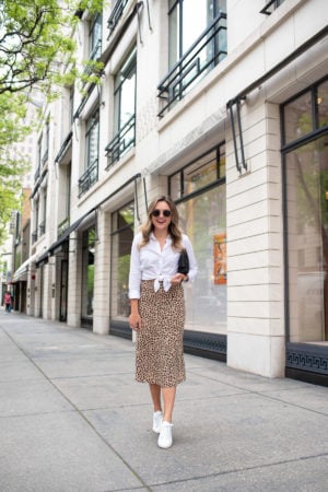 Chicago fashion and lifestyle blogger Jessica Sturdy of Bows & Sequins styling an animal print midi skirt with white leather sneakers on Oak Street in the Gold Coast.