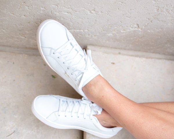 Bows & Sequins wearing the all white leather Keds Ace sneakers.