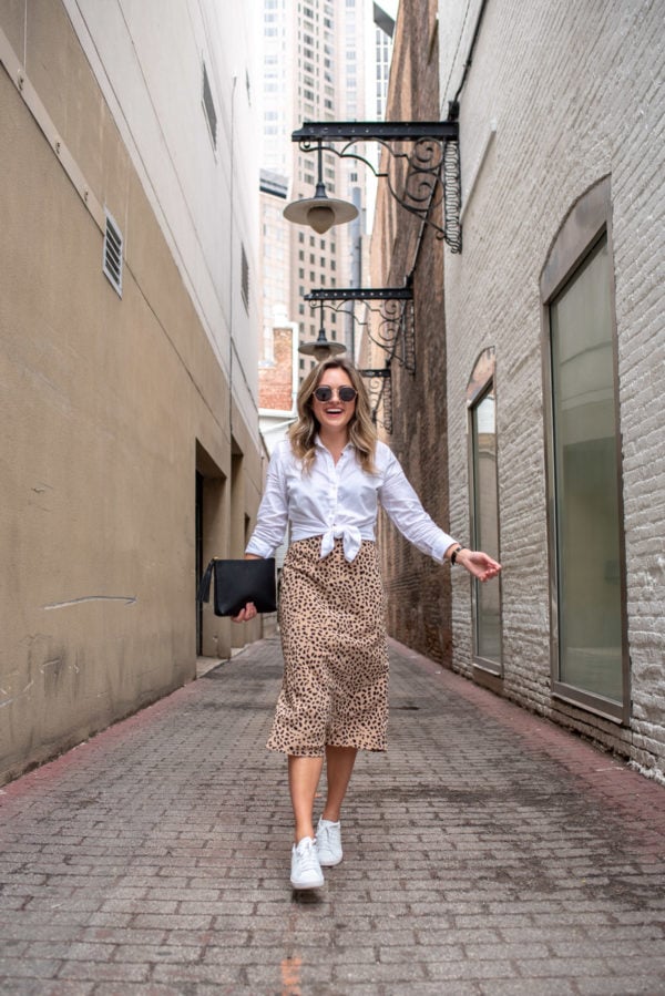 Top Chicago blogger Jessica Sturdy of Bows & Sequins styling a leopard midi skirt with white sneakers.