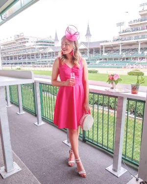 Chicago blogger Jessica Sturdy of Bows & Sequins wearing a pink Vineyard Vines dress at Oaks Day for the Kentucky Derby with pink tassel earrings, a pink fascinator, and white shoes and bag.
