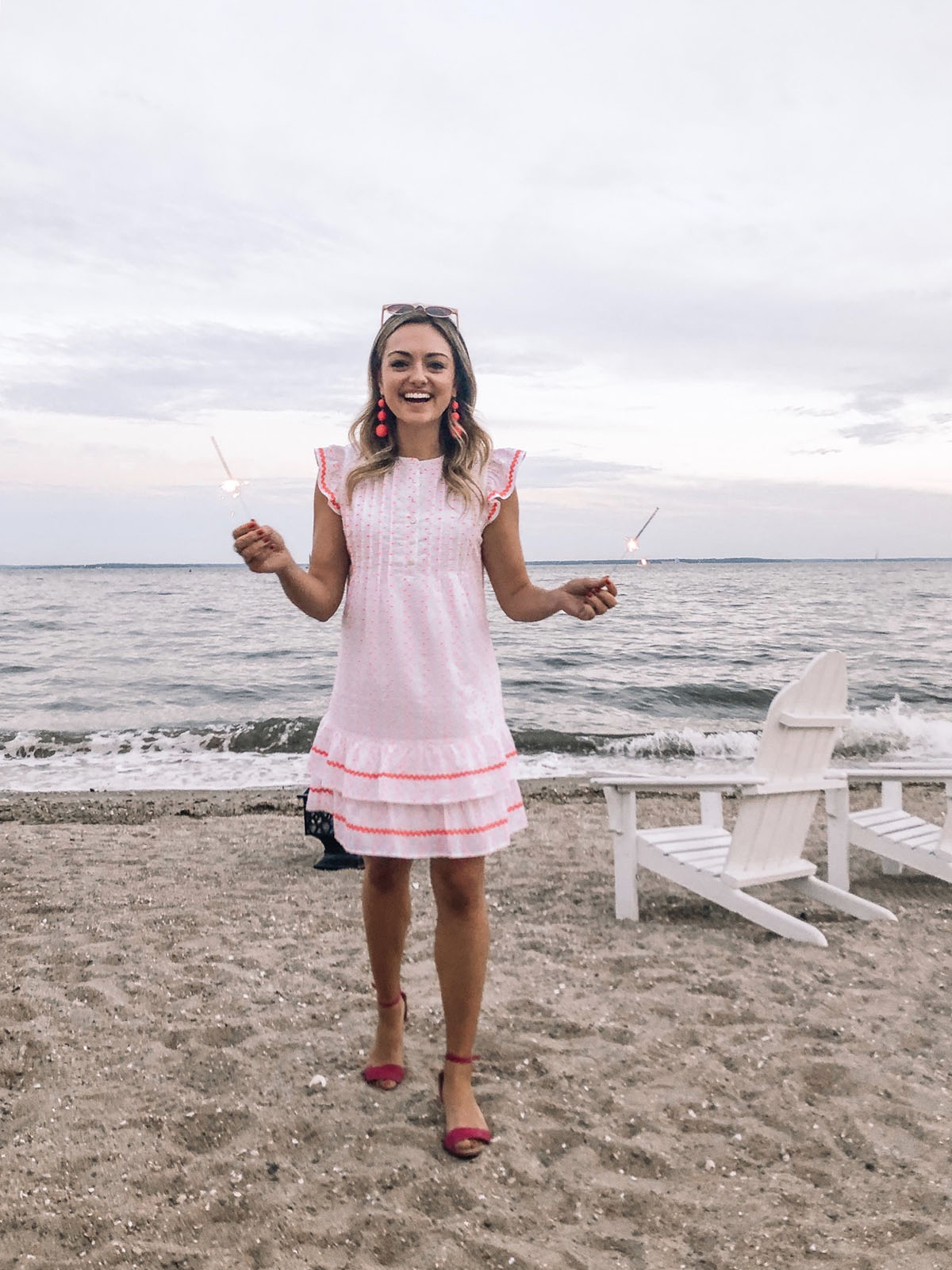 Preppy fashion blogger Jessica Sturdy of Bows & Sequins wearing a Sail to Sable funfetti dress on the beach with sparklers at Wee Burn Beach Club in Rowayton, CT.