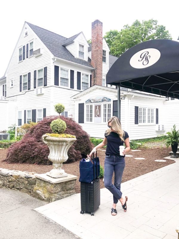 Travel blogger with an Away Bigger Carry-On suitcase outside of the Roger Sherman Inn in New Canaan, Connecticut