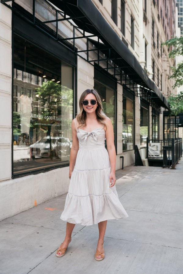 Chicago personal style blogger Jessica Sturdy of Bows & Sequins twirling in a neutral dress in front of rag & bone in the Gold Coast.