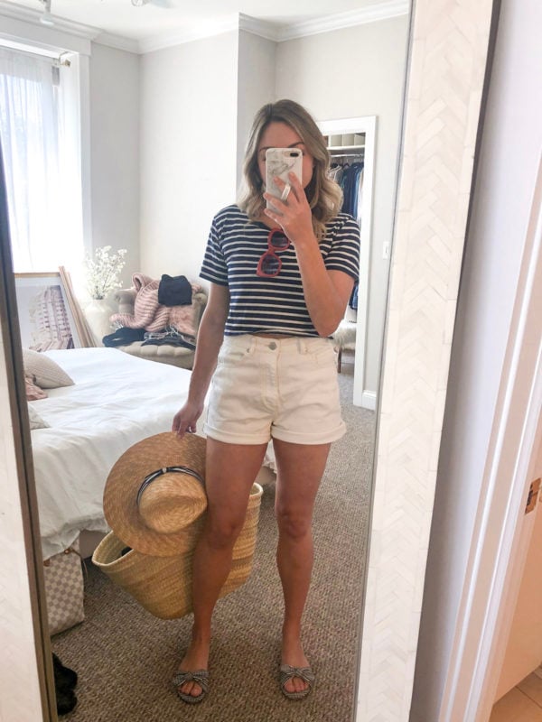 Chicago blogger wearing white high waisted jean shorts with a striped tee and straw tote for boating on Lake Michigan.
